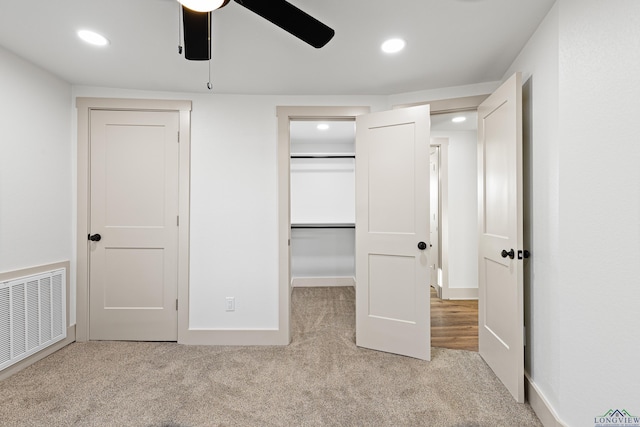 unfurnished bedroom featuring light carpet and ceiling fan