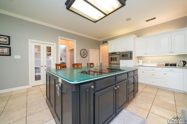 335 Winding Way, Hallsville, TX 75650 - kitchen with stainless steel microwave, white cabinetry, light tile patterned floors, and crown molding