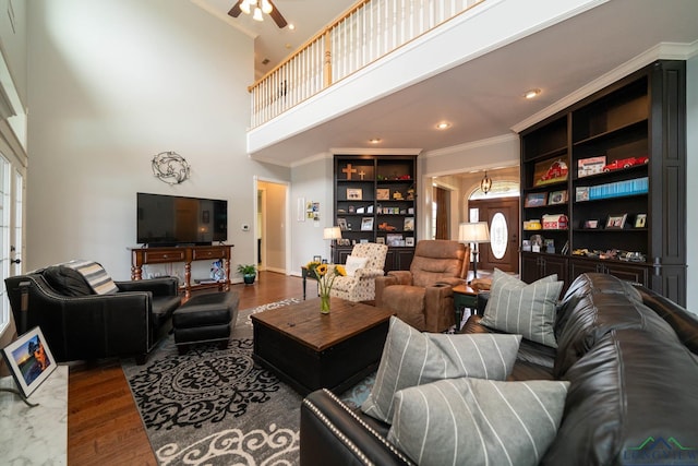 335 Winding Way, Hallsville, TX 75650 - living room featuring a towering ceiling, crown molding, wood finished floors, ceiling fan, and built in shelves