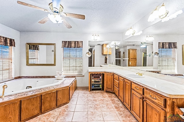 bathroom featuring tile patterned floors, a washtub, vanity, and a textured ceiling