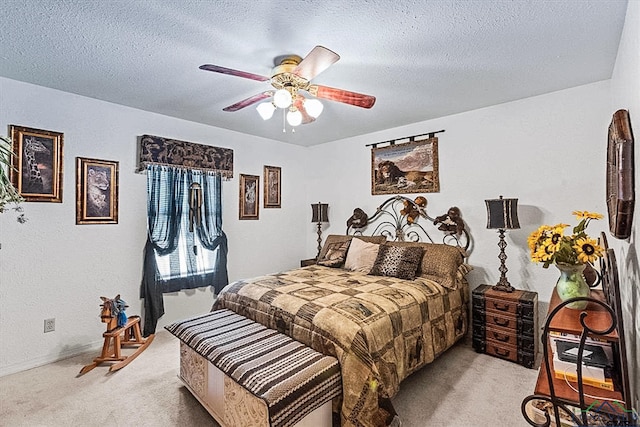 bedroom with ceiling fan, light colored carpet, and a textured ceiling