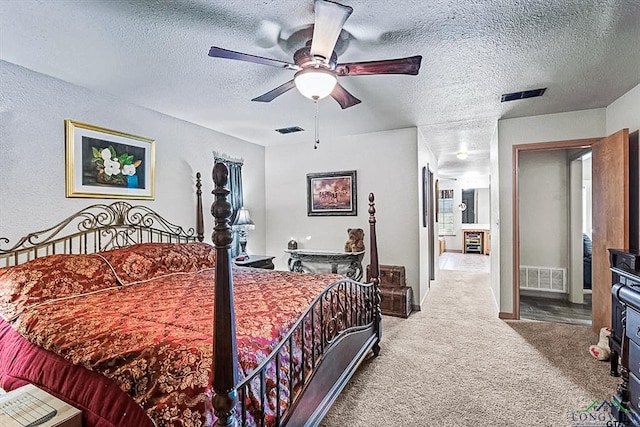 carpeted bedroom featuring ceiling fan and a textured ceiling