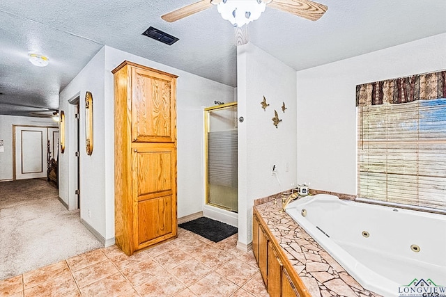 bathroom with plus walk in shower, a textured ceiling, ceiling fan, and tile patterned flooring