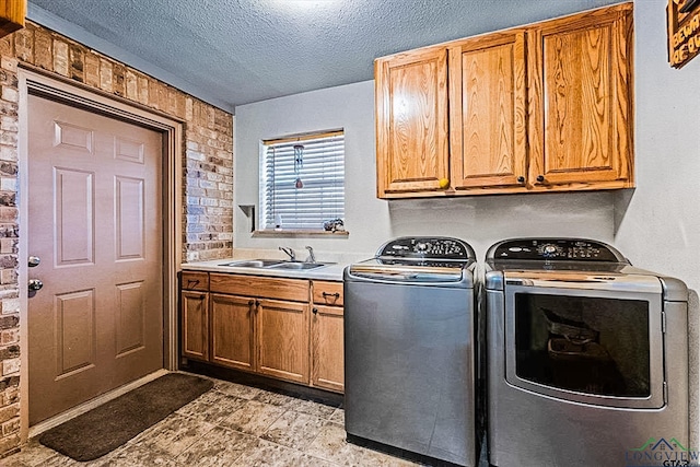 washroom with washer and clothes dryer, cabinets, sink, and a textured ceiling