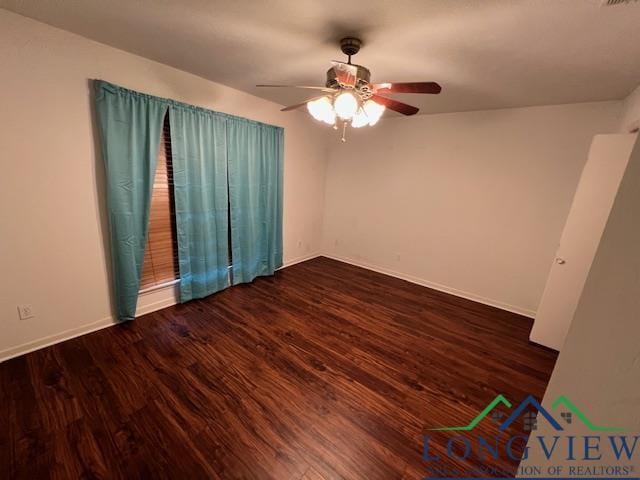 empty room with ceiling fan and dark hardwood / wood-style flooring