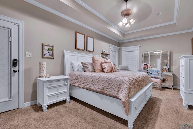 carpeted bedroom with a raised ceiling, ceiling fan, and ornamental molding