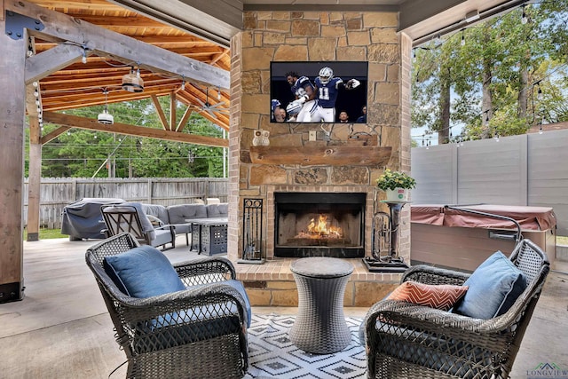 view of patio with an outdoor stone fireplace, a hot tub, and a gazebo