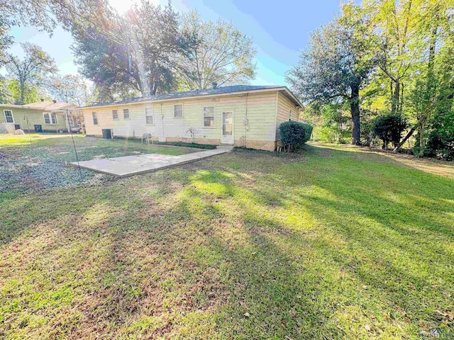 rear view of property featuring a patio area and a yard