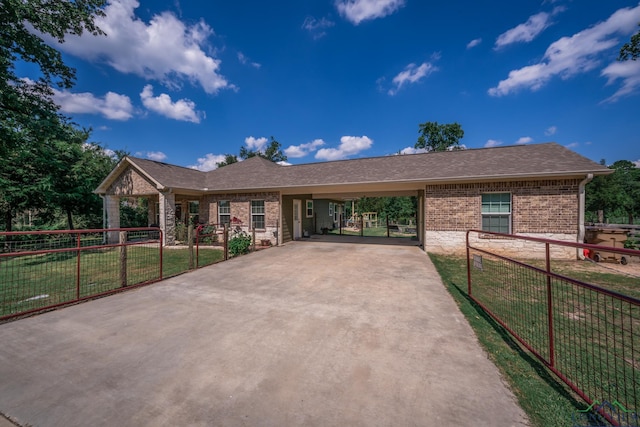 single story home featuring brick siding, concrete driveway, fence, an attached carport, and a front lawn