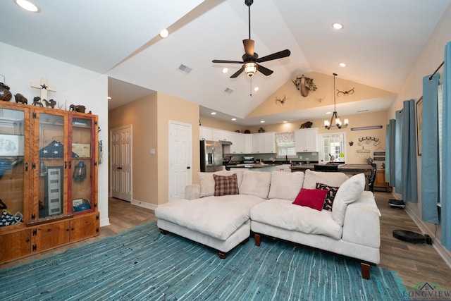 living area with high vaulted ceiling, recessed lighting, ceiling fan with notable chandelier, wood finished floors, and visible vents