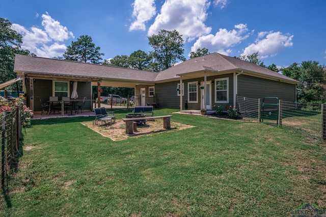 rear view of property with a patio area, a lawn, fence, and a carport