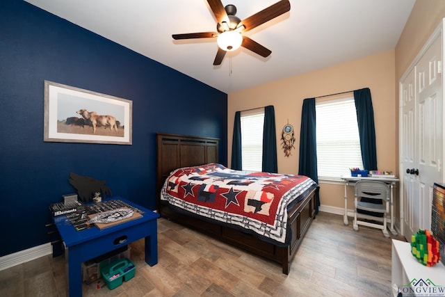 bedroom featuring ceiling fan, baseboards, and wood finished floors