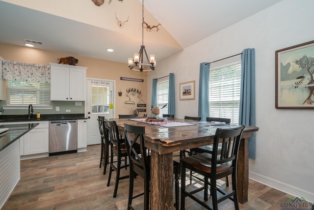 dining room featuring a chandelier, recessed lighting, dark wood-type flooring, baseboards, and vaulted ceiling