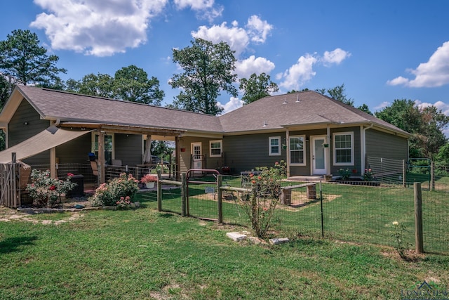 back of house featuring a yard, a shingled roof, fence, and a gate