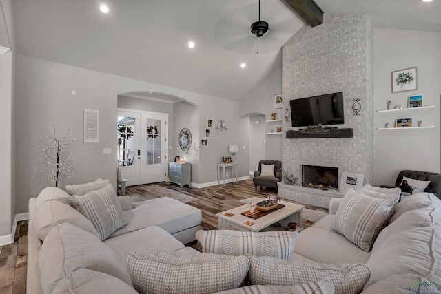 living room with french doors, hardwood / wood-style flooring, ceiling fan, a fireplace, and beam ceiling