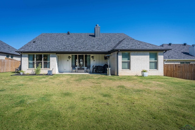 back of house featuring a patio area and a yard