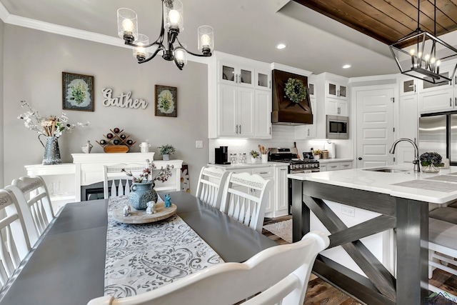 dining area featuring dark wood-type flooring, an inviting chandelier, sink, ornamental molding, and wood ceiling