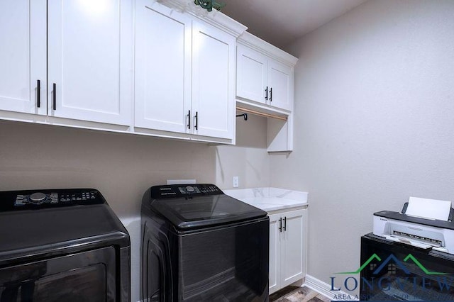 clothes washing area featuring cabinets and independent washer and dryer