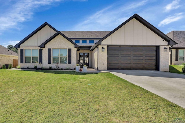 view of front of home with a front yard, french doors, and a garage