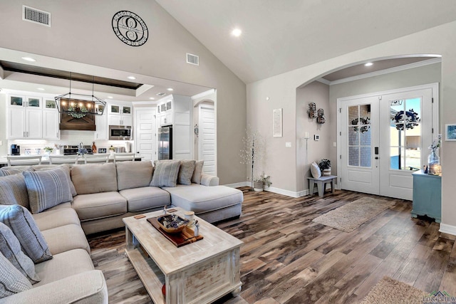 living room featuring dark hardwood / wood-style flooring, crown molding, and a chandelier