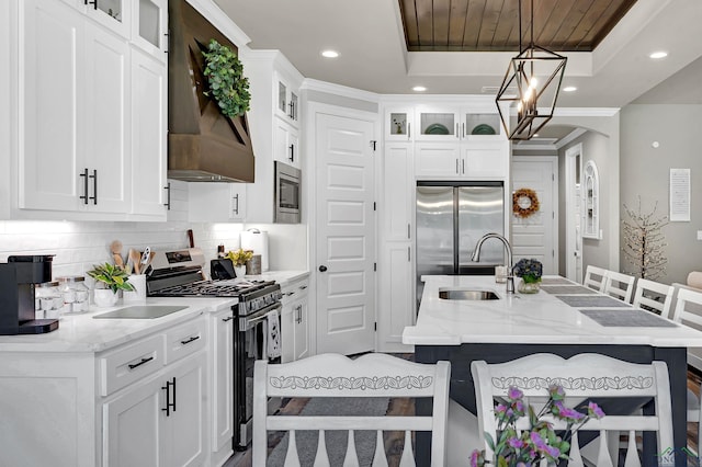 kitchen featuring light stone countertops, an island with sink, decorative light fixtures, a breakfast bar, and appliances with stainless steel finishes