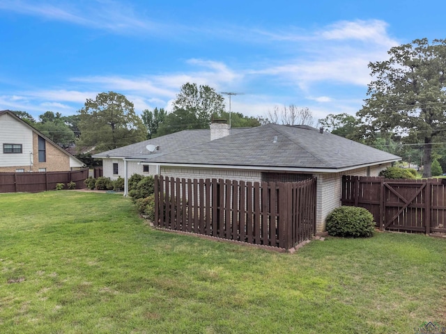 rear view of house with fence private yard, a chimney, a shingled roof, a yard, and brick siding