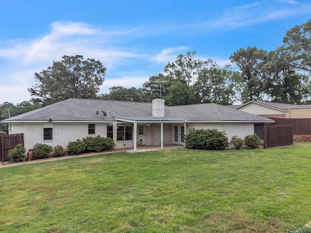 back of property with fence, a yard, a patio area, and brick siding
