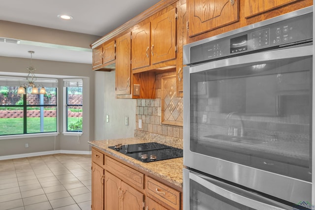 kitchen featuring black electric cooktop, visible vents, baseboards, backsplash, and light tile patterned floors