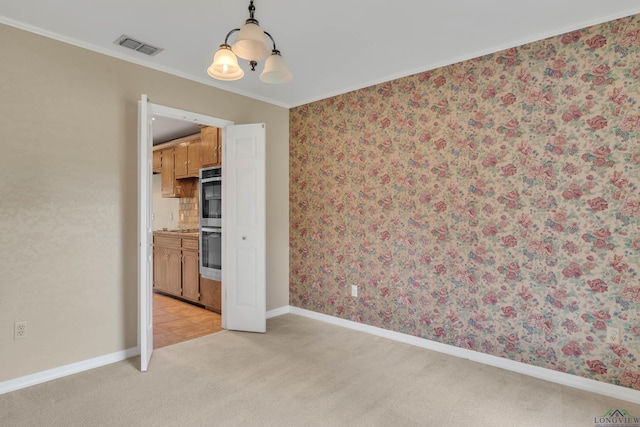 spare room featuring light colored carpet, visible vents, wallpapered walls, baseboards, and ornamental molding