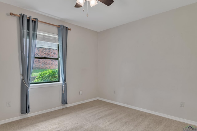 carpeted empty room with a ceiling fan and baseboards