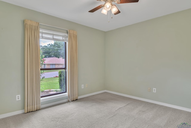 carpeted spare room with baseboards and ceiling fan