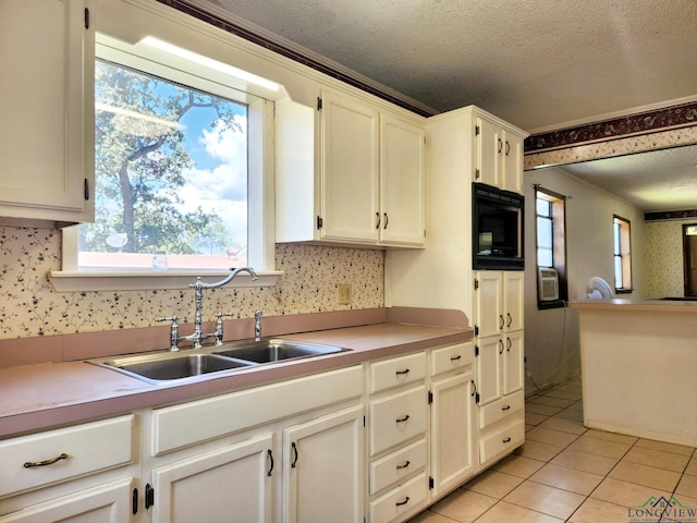 kitchen with white cabinetry, black microwave, sink, a textured ceiling, and light tile patterned floors