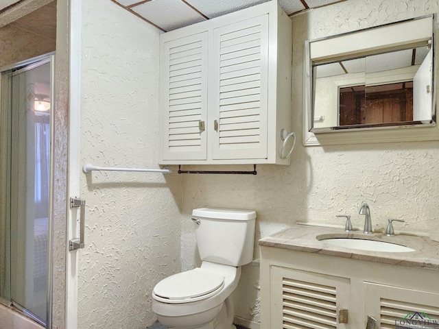 bathroom with vanity, toilet, and a shower with door