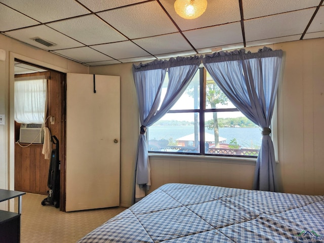 bedroom with cooling unit, a water view, and wooden walls