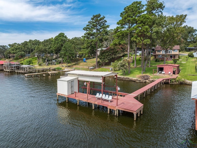 view of dock with a yard and a water view