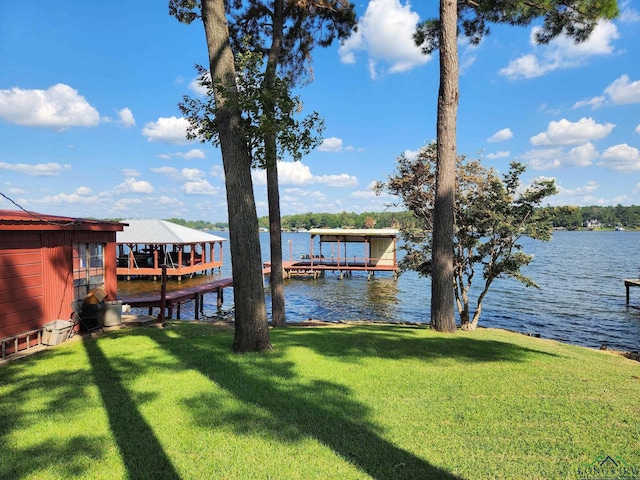 dock area with a lawn and a water view