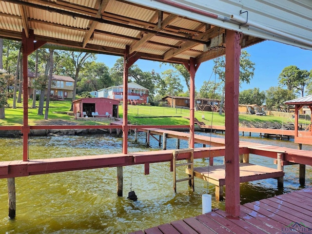 view of dock featuring a lawn and a water view