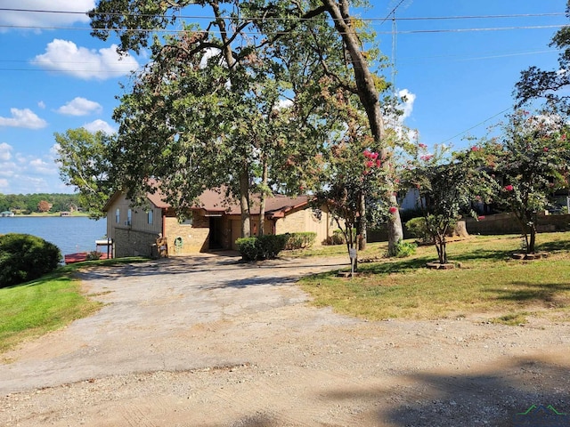 view of front facade featuring a front lawn and a water view