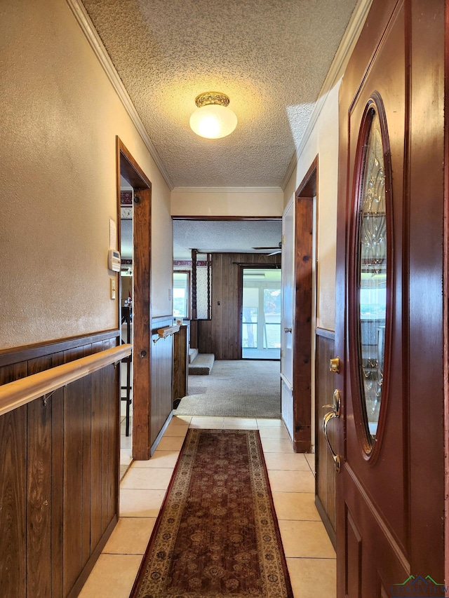 interior space featuring light tile patterned floors, a textured ceiling, and ornamental molding