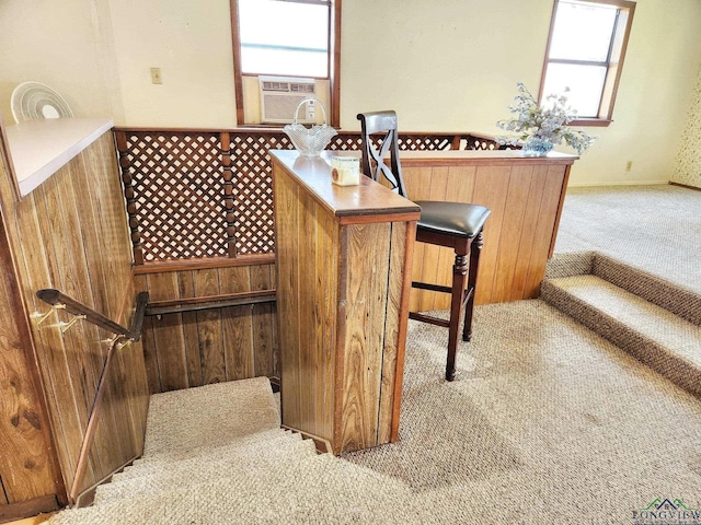 bar with plenty of natural light, cooling unit, and light colored carpet