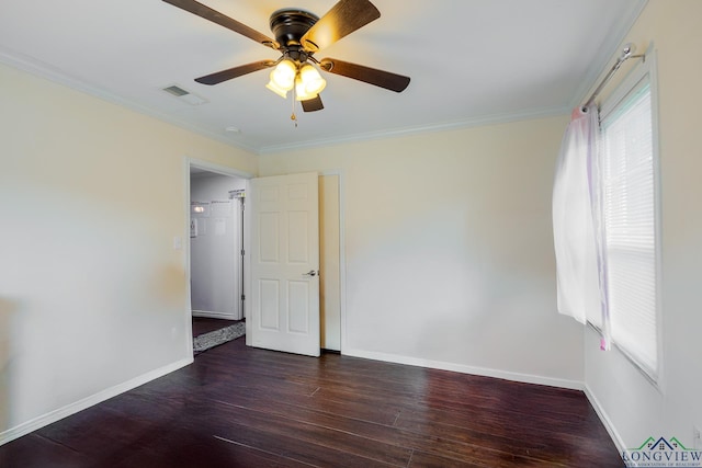 spare room with baseboards, ornamental molding, wood finished floors, and visible vents