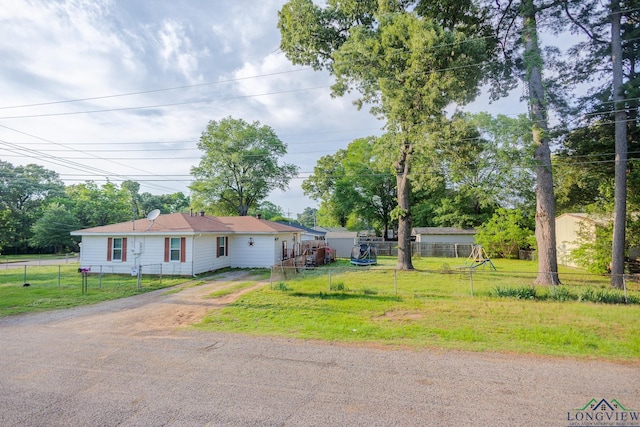 view of front of property featuring fence, dirt driveway, and a front yard