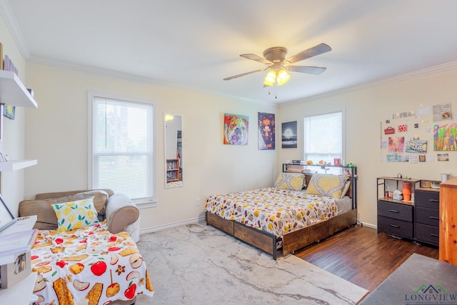 bedroom with crown molding, baseboards, wood finished floors, and multiple windows