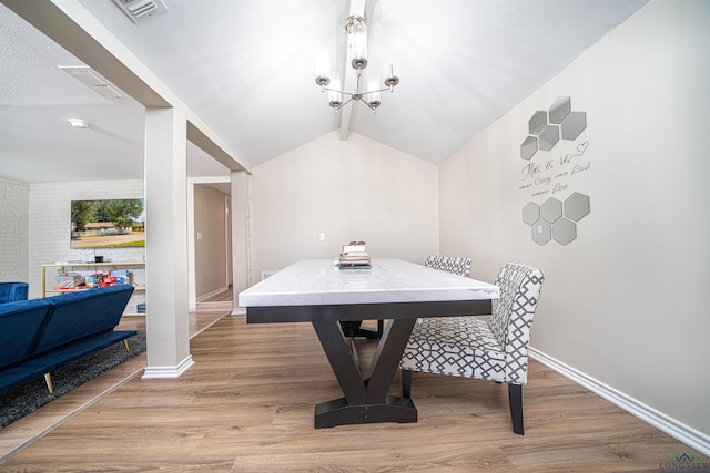 dining area featuring vaulted ceiling, a notable chandelier, and hardwood / wood-style flooring