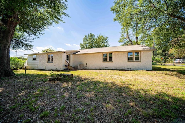 rear view of house featuring a yard and central AC unit