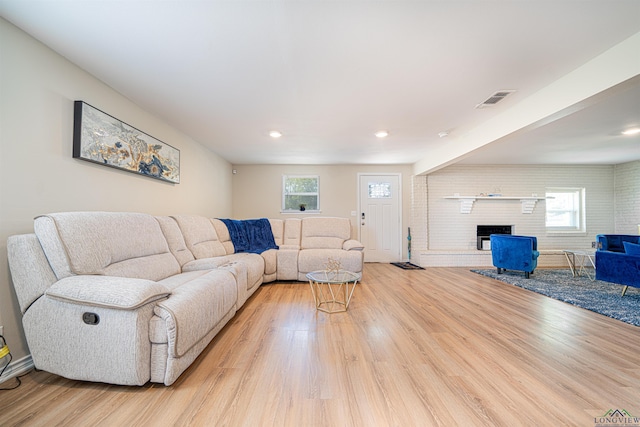 living room with light wood-type flooring and a fireplace