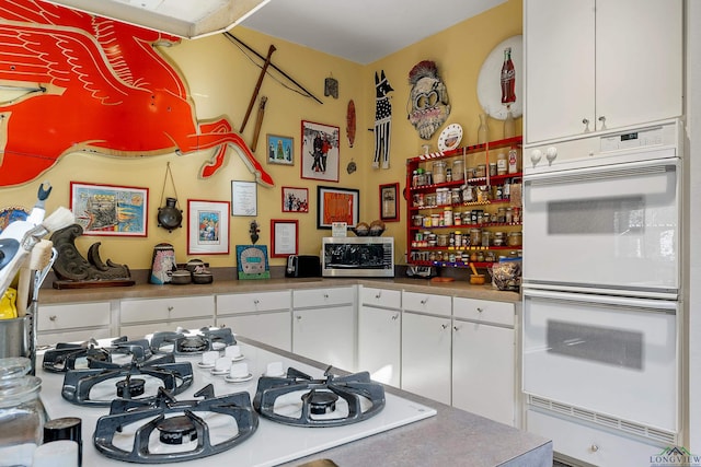 kitchen featuring white cabinetry and white appliances