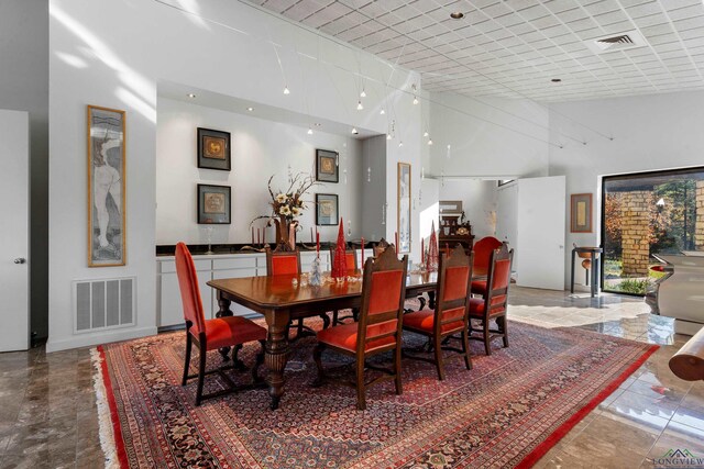 dining room with a towering ceiling