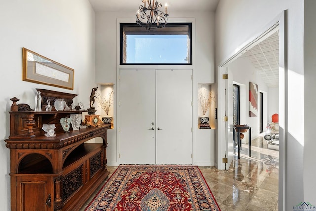 entrance foyer with a towering ceiling and an inviting chandelier