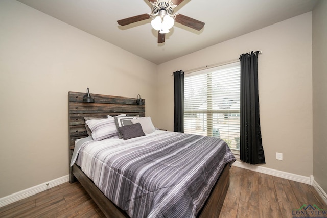 bedroom with ceiling fan, wood finished floors, and baseboards